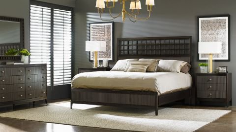 Stylish bedroom furniture set featuring a bed with a cushioned headboard, side tables, and a matching wardrobe.